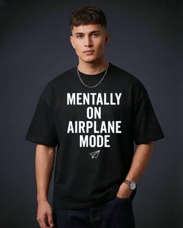 A close-up view of a male model wearing our black t shirt oversized with the "MENTALLY ON AIRPLANE MODE" print.
